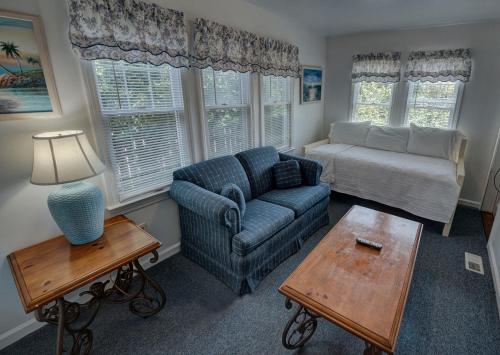 a living room with a couch and a chair and a table at Outer Banks Motel - Village Accommodations in Buxton