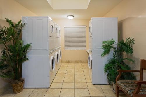 a laundry room with white appliances and palm trees at Staybridge Suites Tallahassee I-10 East by IHG in Tallahassee