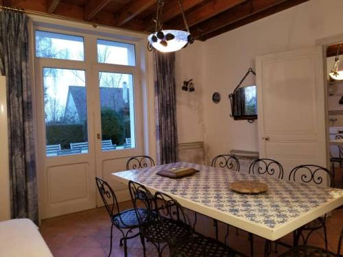 een eetkamer met een tafel en stoelen en een raam bij Maison de Charme à Wissant in Wissant