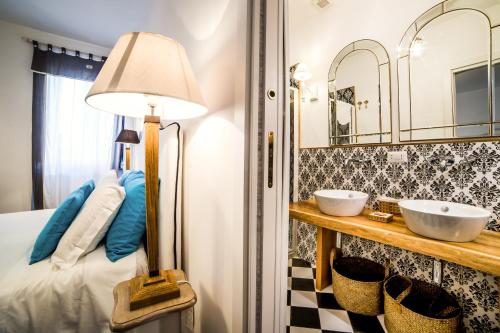 a bedroom with a bed and two sinks and a lamp at Maison Fernanda in SantʼAgata sui Due Golfi