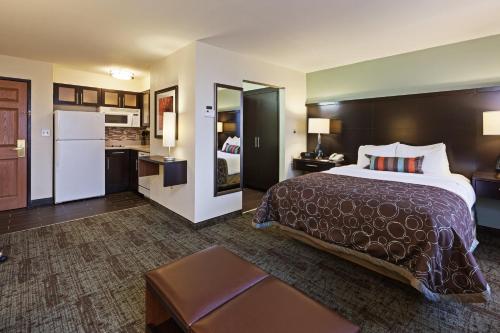 Staybridge Suites Tulsa-Woodland Hills, an IHG Hotel tesisinde bir odada yatak veya yataklar