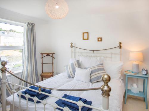 a bedroom with a bed and a window at Swn y Mor Sound of the Sea in Criccieth