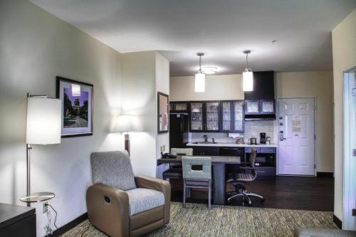 Il comprend un salon avec une chaise et une cuisine. dans l'établissement Candlewood Suites - Austin North, an IHG Hotel, à Austin