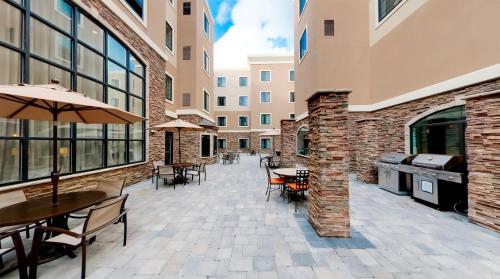 an outdoor patio with tables and chairs in a building at Staybridge Suites Ann Arbor - Research Parkway by IHG in Ann Arbor