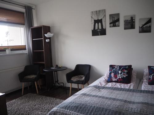 1 dormitorio con 1 cama, 2 sillas y mesa en Szybowników 1 en Piła