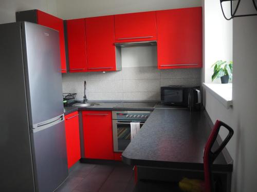 eine Küche mit roten Schränken und einer Arbeitsplatte in der Unterkunft Szybowników 1 in Piła