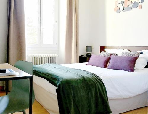 1 dormitorio con 1 cama con sábanas moradas y verdes en HOTEL DU MIDI en Beaufort-sur-Gervanne