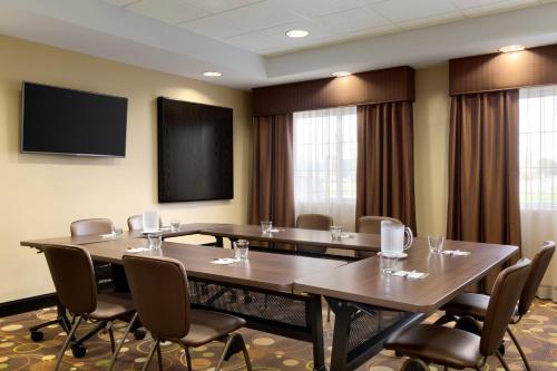 a conference room with tables and chairs and a flat screen tv at Staybridge Suites West Edmonton by IHG in Edmonton