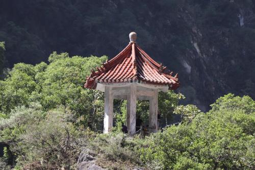 a gazebo with a red roof on top of trees at Yu Shou Hao Hsien Guesthouse in Fushi