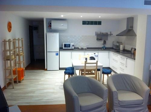 a kitchen with a table and chairs and a refrigerator at Corazón de Nervión, excelente ubicación, opcion PARKING in Seville