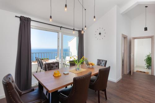 a dining room with a table and a view of the ocean at Apartments Galic in Podgora