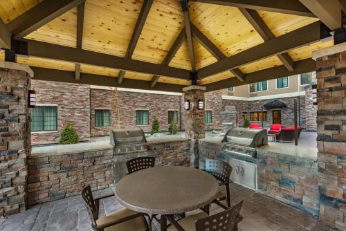 an outdoor patio with a table and a grill at Staybridge Suites Anchorage by IHG in Anchorage