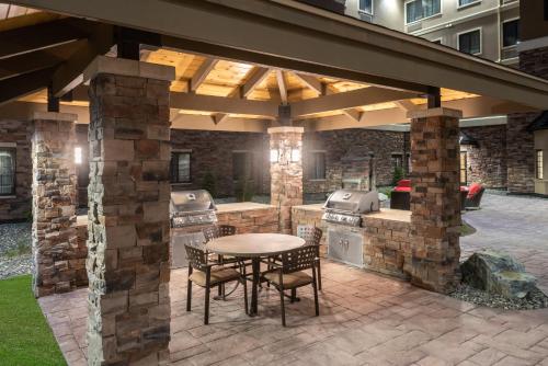 an outdoor kitchen with a table and a grill at Staybridge Suites Anchorage by IHG in Anchorage
