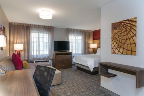 a hotel room with a bed and a living room at Staybridge Suites Anchorage by IHG in Anchorage