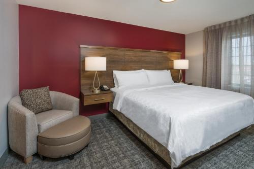 a hotel room with a large bed and a chair at Staybridge Suites Anchorage by IHG in Anchorage