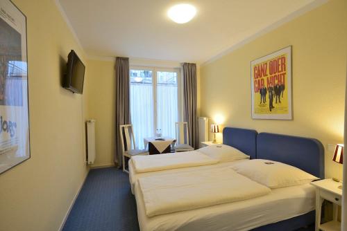 a hotel room with two beds and a window at ALPHA Hotel Garni in Hamburg