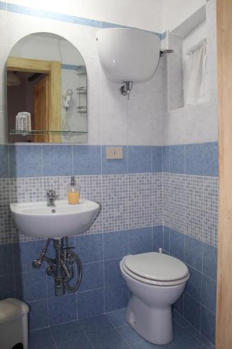 a blue tiled bathroom with a toilet and a sink at Antica Dimora in Monteroni dʼArbia