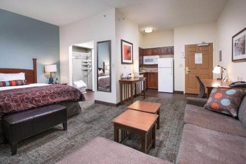 a hotel room with a bed and a living room at Staybridge Suites Augusta by IHG in Augusta