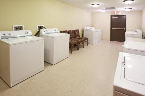 a laundry room with washers and dryers and chairs at Staybridge Suites Augusta by IHG in Augusta