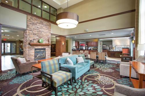 a lobby with a couch and chairs and a fireplace at Staybridge Suites Augusta by IHG in Augusta