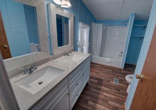 a bathroom with a sink and a toilet and a mirror at Outer Banks Motel - Village Accommodations in Buxton