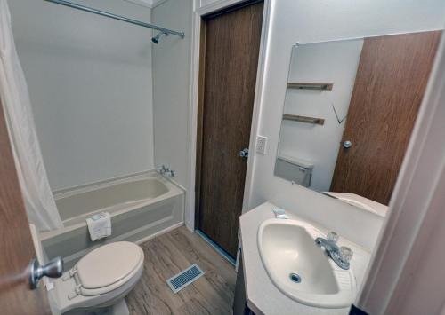 a bathroom with a sink and a toilet and a tub at Outer Banks Motel - Village Accommodations in Buxton