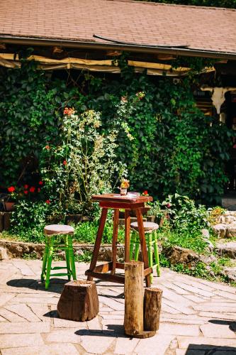 a table and two stools in front of a garden at Guest House Kraljev Hrib in Kamniška Bistrica