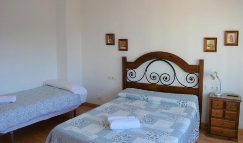 a small bedroom with two beds and a dresser at Casa Duende del Tajo in Ronda