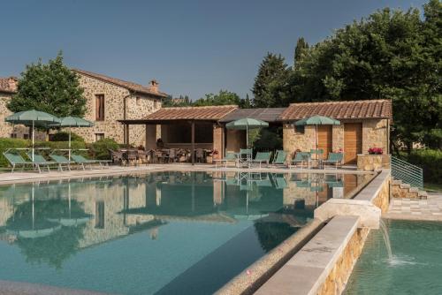 a large swimming pool in front of a house at Antica Fonte Resort in Casole dʼElsa