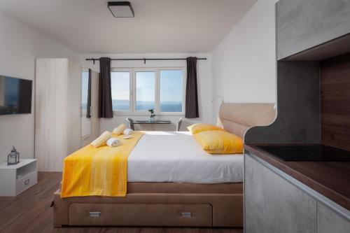 a bedroom with a large bed with yellow pillows at Apartments Galic in Podgora
