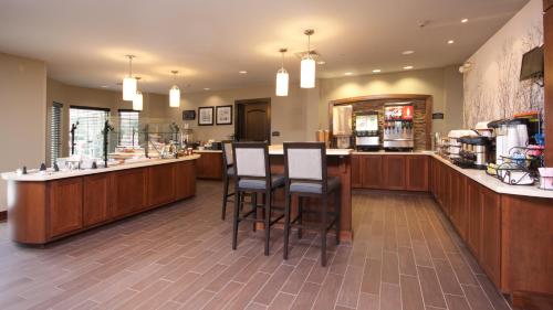 a restaurant with a bar with stools at a counter at Staybridge Suites Buffalo-Amherst by IHG in Amherst