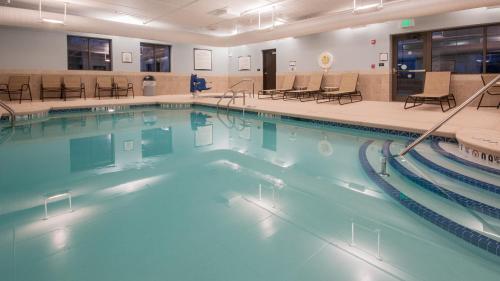a swimming pool with blue water in a building at Staybridge Suites Buffalo-Amherst by IHG in Amherst