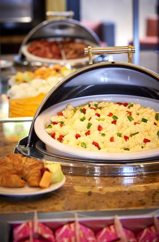 a buffet of food on a table with a plate of food at Staybridge Suites Hamilton - Downtown by IHG in Hamilton