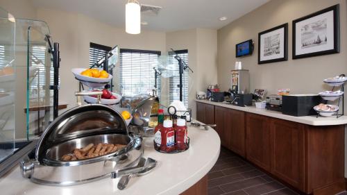 a kitchen with a sink and a counter with food at Staybridge Suites Buffalo-Amherst by IHG in Amherst