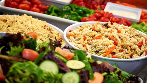 a buffet of food with pasta salad and vegetables at Staybridge Suites Hamilton - Downtown by IHG in Hamilton