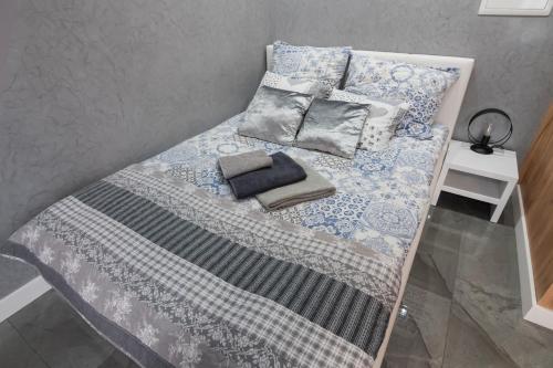 a bed with a blue and white blanket and pillows at Apartament Panorama in Nowy Targ
