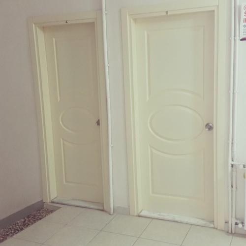 two white doors in a room with a tile floor at Thermal Orkide Pansiyon in Yalova