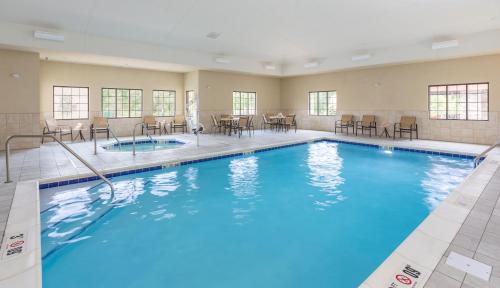 a pool with blue water in a hotel room at Staybridge Suites Canton by IHG in North Canton