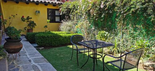 a patio with a table and chairs in a yard at Hotel Ocho Barrios in San Cristóbal de Las Casas