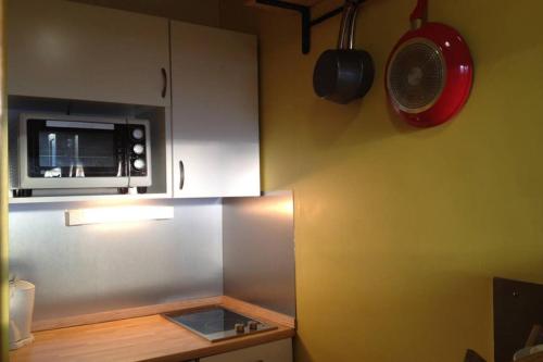 a small kitchen with a microwave and a counter at Appartement Chamonix - Vue Mont Blanc in Chamonix