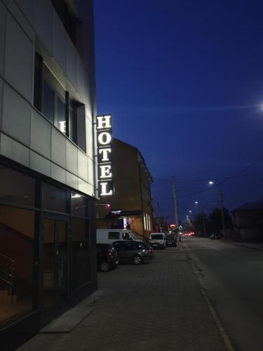 una señal de hotel en el lateral de un edificio por la noche en LEX Trend Hotel, en Irpín