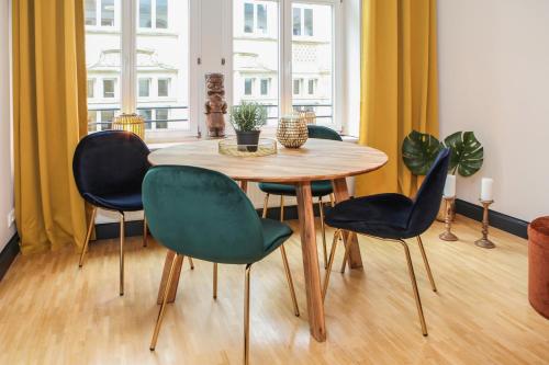 een tafel en vier stoelen in een kamer bij Sleepwell Apartment - Klostersuite in Leipzig