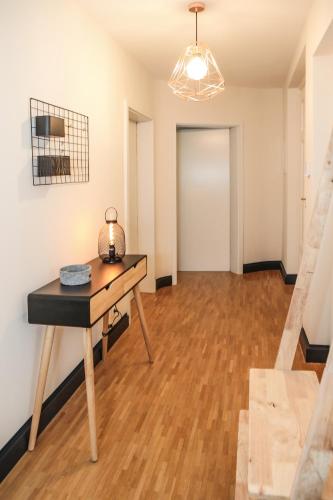 an empty room with a table and a hallway at Sleepwell Apartment - Klostersuite in Leipzig