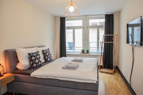 um quarto com um sofá, uma televisão e uma janela em Sleepwell Apartment - Klostersuite em Leipzig
