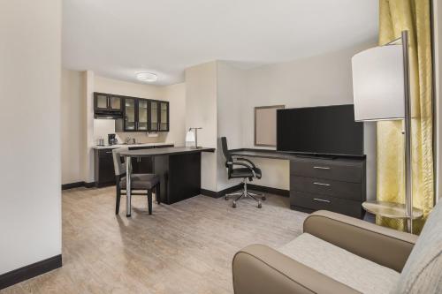 a living room with a desk and a computer in a room at Candlewood Suites - Charlotte - Arrowood by IHG in Charlotte