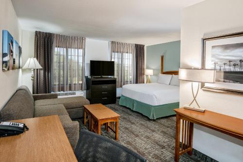 a hotel room with a bed and a living room at Staybridge Suites Austin Round Rock by IHG in Round Rock