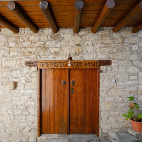 a wooden door on a stone building with a wooden roof at Constantias stone houses in Lofou