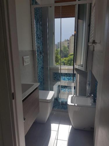 a bathroom with a sink and a toilet and a window at RESIDENCE Green Beverly con piscina in Lido Adriano