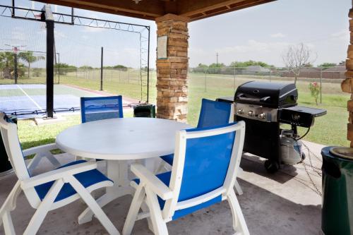 a white table and chairs and a grill on a patio at Staybridge Suites - Brownsville by IHG in Brownsville
