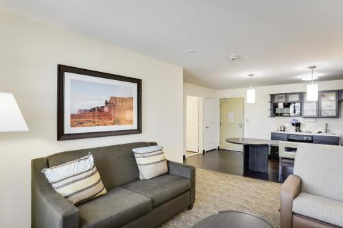 a living room with a couch and a kitchen at Candlewood Suites College Station by IHG in Bryan